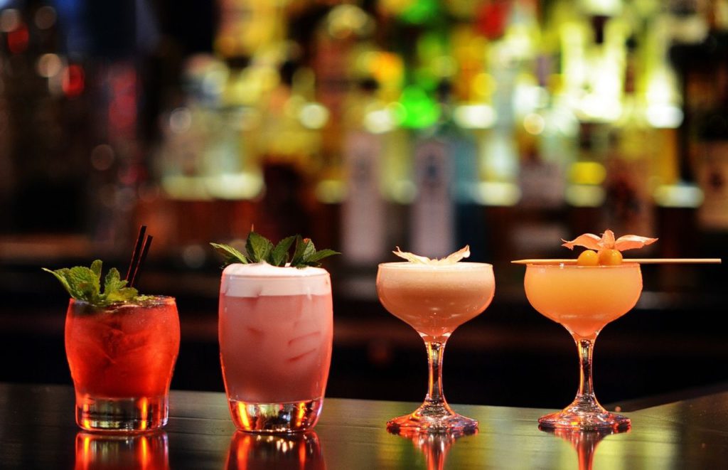 Colorful cocktails lined up on the bar. Keep reading to find out all about the things to do in Gainesville at night.