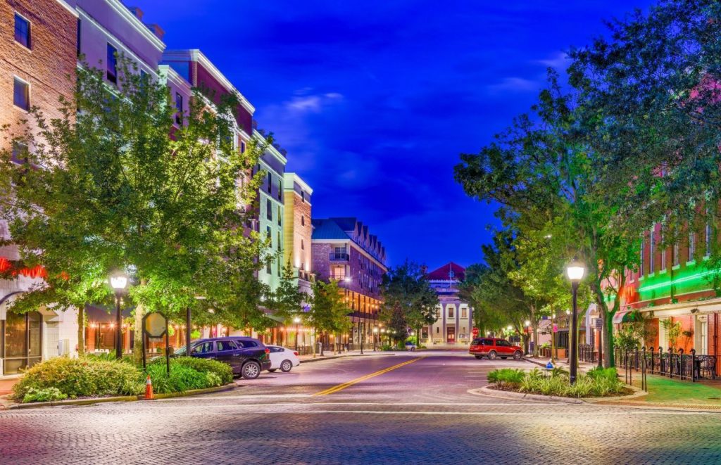 Downtown Gainesville at Nighttime with the glow of the shop and street lights. Keep reading to learn more about Gainesville nightlife. 