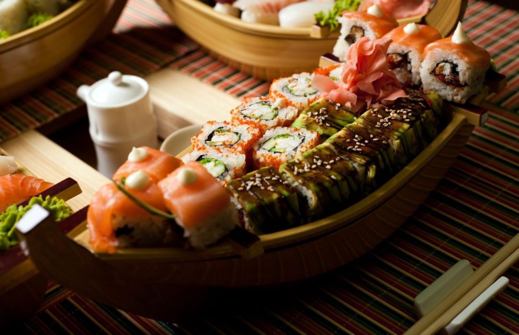 Boat sushi dish of several types of from avocado covered to salmon covered to rice covered rolls topped with sesame seeds and fresh ginger. Keep reading to get the full guide on where to go for the best sushi in Tampa, Florida. 