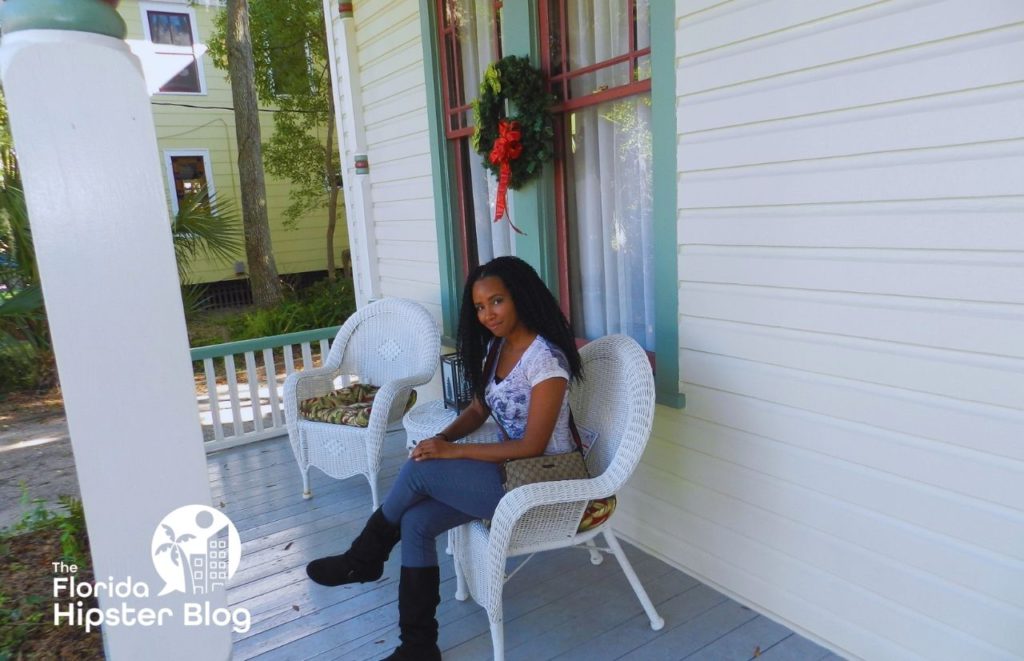 63 Orange Street Bed and Breakfast in St Augustine Florida With NikkyJ sitting on the front porch. Keep reading for the best things to do in St. Augustine for Christmas!