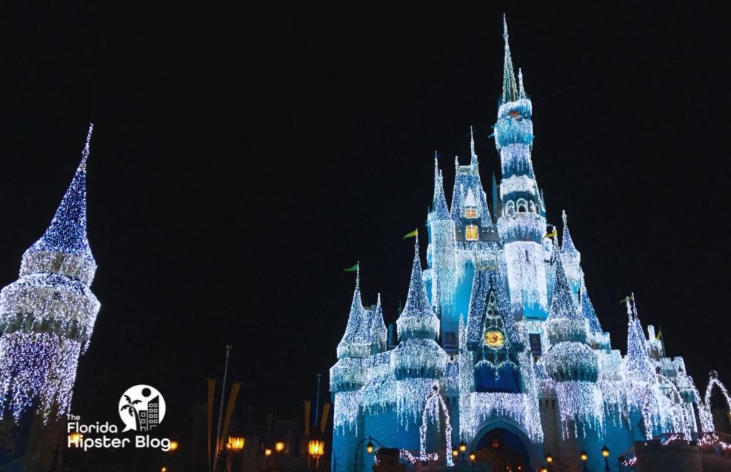 Cinderella Castle decked out in white Christmas Lights Magic Kingdom. Keep reading to learn more about things to do in Florida at Christmas.