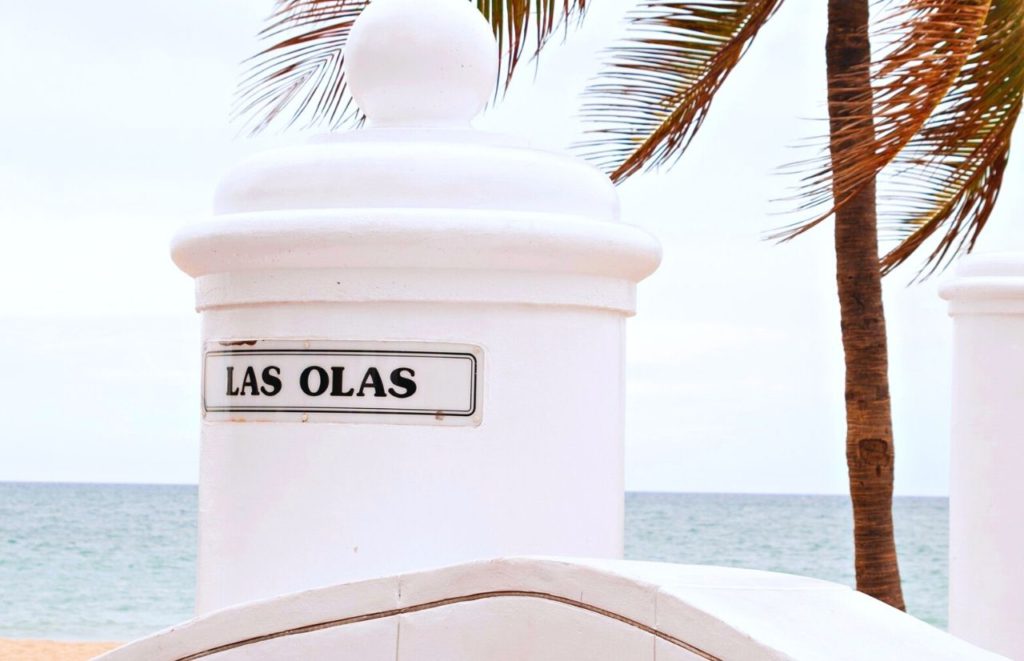 Las Olas Fort Lauderdale Florida sign under a palm tree. Keep reading to find out more things to do in Florida at Christmas for 2023. 