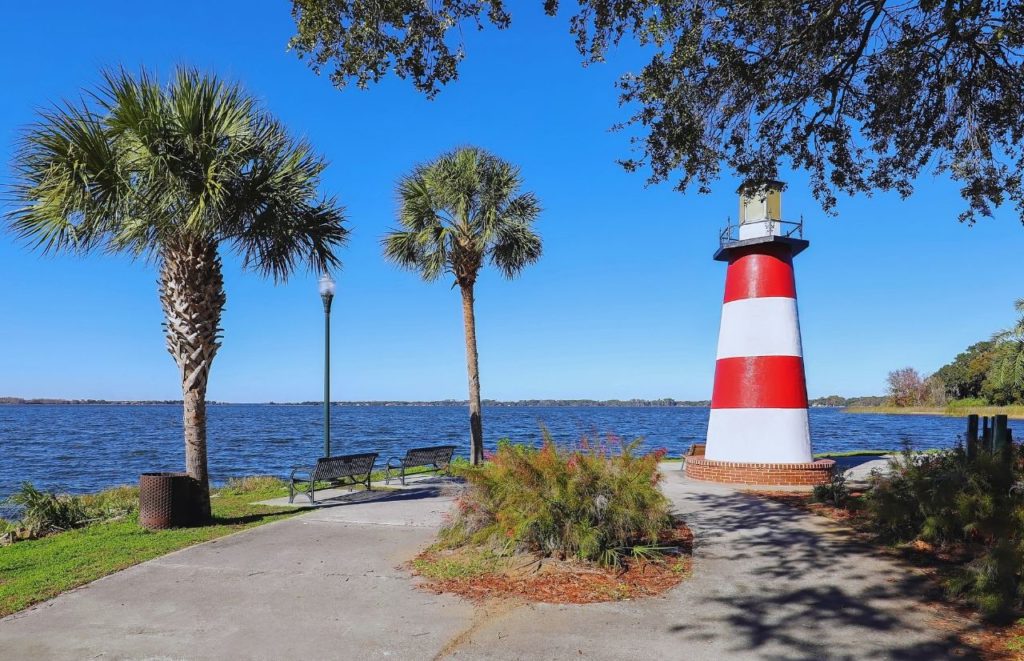 Mount Dora Florida Grantham Point with lighthouse and benches at the water. Keep reading to find out more things to do in Florida at Christmas for 2023. 