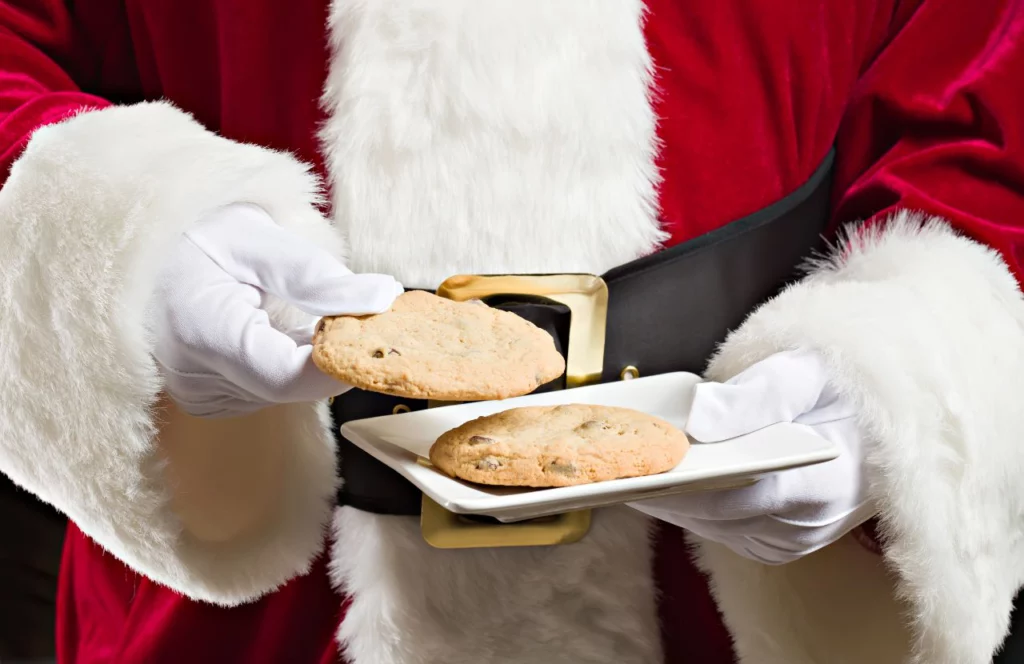 Santa Claus holding chocolate cookies at an event, one of the best things to do in Florida for Christmas. Keep reading to learn more about Christmas in Tampa events. 