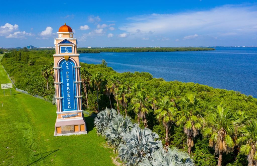 A marker welcoming visitors to St. Petersburg, Florida overlooks the water. Keep reading for more places to take a perfect day trip from Orlando, Florida. 