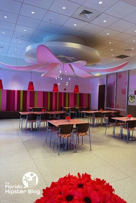 Pink with large hanging bow chandelier at American Girl Bistro Dining Area Orlando Florida. Keep reading to find out more about kid friendly restaurants in Orlando.