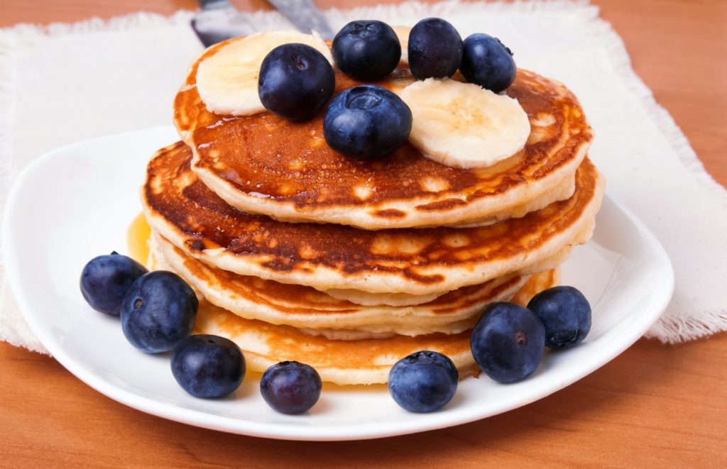 Briarpatch Winter Park Bruch Pancakes with bananas blueberries and syrup making it one of the best places to have brunch in Winter Park, Florida. Keep reading to discover where to go for brunch in Winter Park. 
