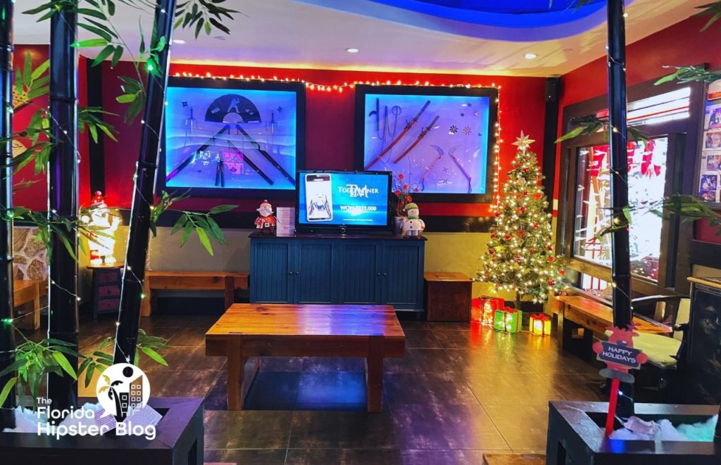 Interior at Kobe Japanese Steakhouse in Orlando in traditional red and black colors, artwork and bamboo with twinkle lights. Keep reading to find out all you need to know about the best Japanese food in Orlando. 