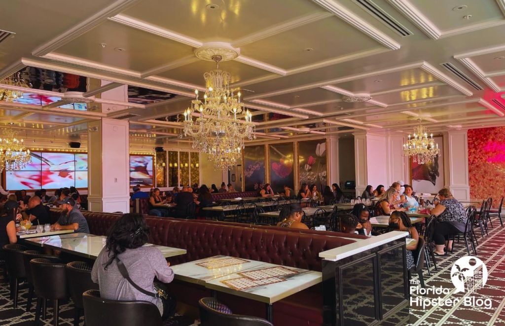 Sugar Factory Interior with booth seating and tables and hanging chandeliers in Orlando Florida. Keep reading to find out the best kid restaurants in Orlando. 