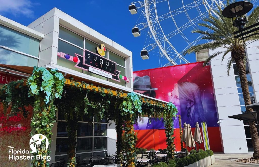 Sugar Factory exterior shot with Orlando ICON Park and ferries wheel in the background. Keep reading to learn more about things to do in Orlando for your birthday.