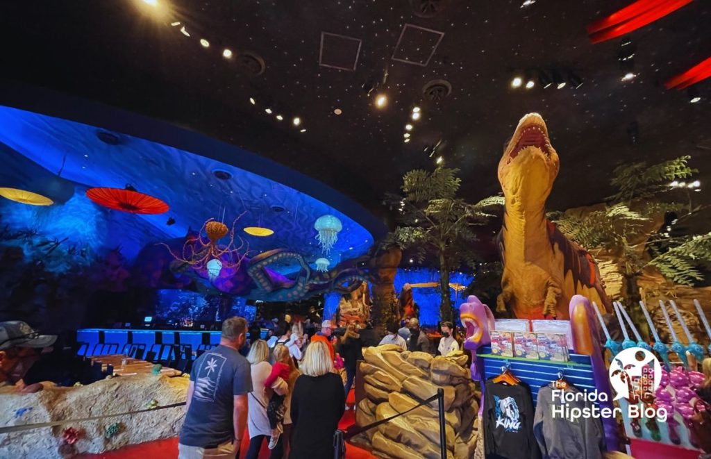 T Rex Cafe Interior at Disney Springs with larger than life dinosaur and merchandise. Keep reading to find out all you need to know about the best kid restaurants in Orlando. 