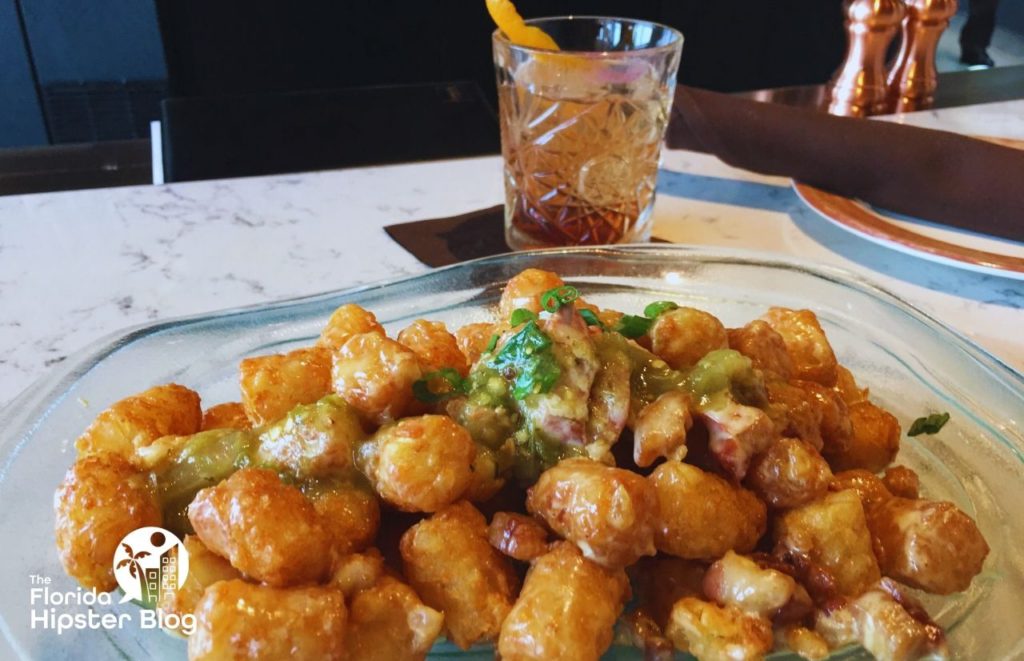 Toothsome Chocolate Emporium Loaded Tots and Manhattan Drink. Keep reading to find out the best dessert in Orlando. 