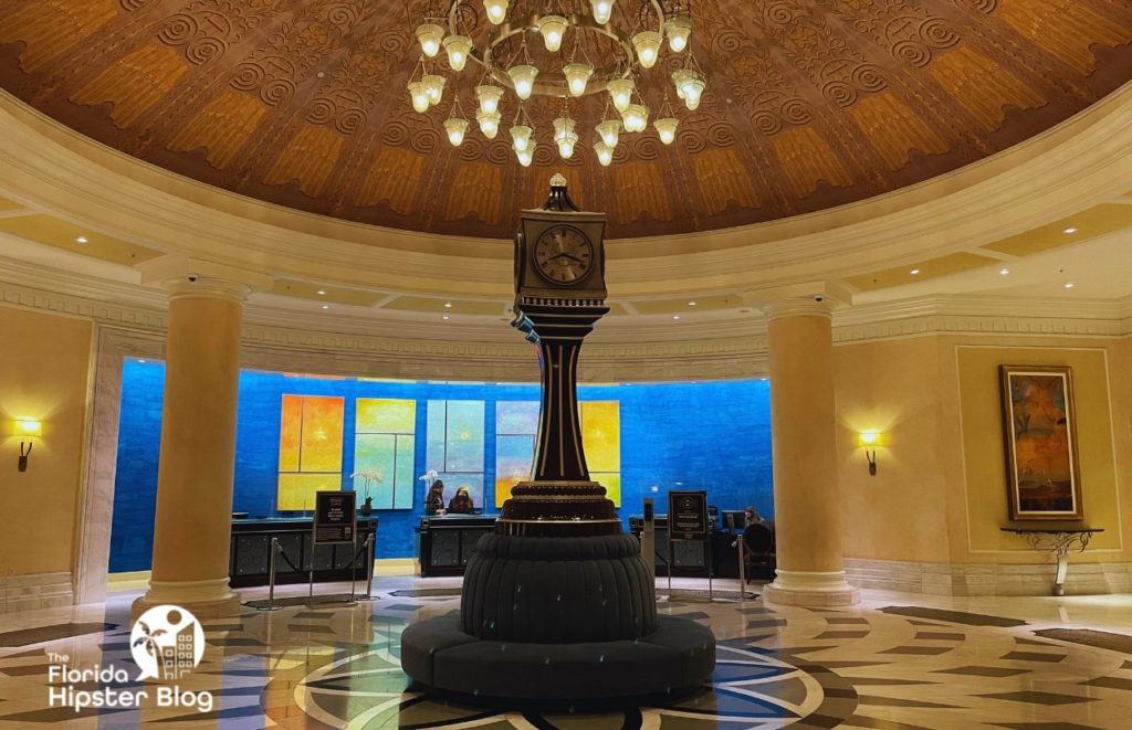 Hanging chandelier and large antique clock at Bull and Bear at Waldorf Astoria Orlando Florida. Keep reading to find out more about the Epicurious progressive dinner.