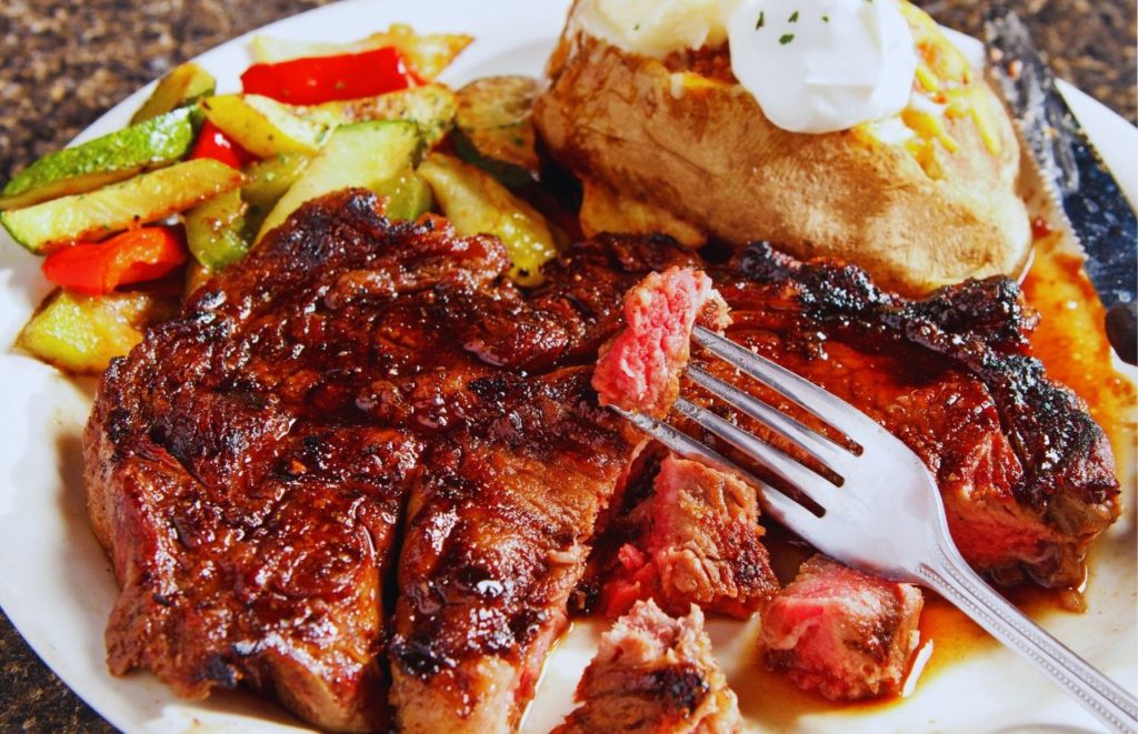 Delmonico's Italian Steakhouse in Orlando with fully loaded baked potato, vegetables and steak.