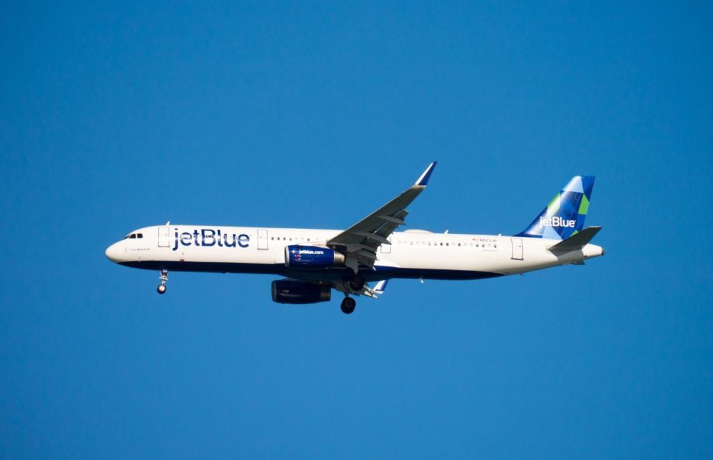 JetBlue Airplane in the sky. Keep reading for all you need to know about taking both a backpack and a carry-on for your next flight. 