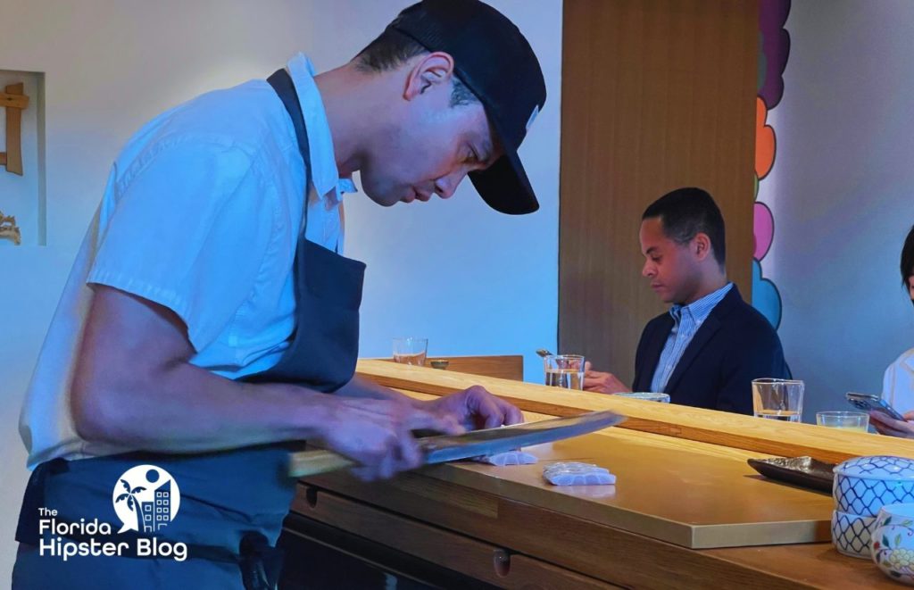 Mark, an owner of Kadence Sushi in Orlando, Florida, prepares sushi behind the bar. Keep reading for more on the best restaurants in Orlando, Florida. 