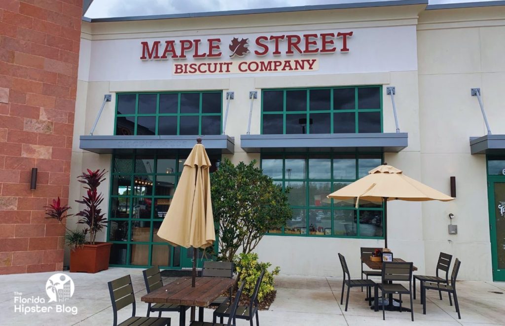 Tables, chairs, and umbrellas sit outside the entrance of the Maple Street Biscuit Company in Kissimmee, Florida. Keep reading for more places to get the best breakfast in Kissimmee, Florida. 