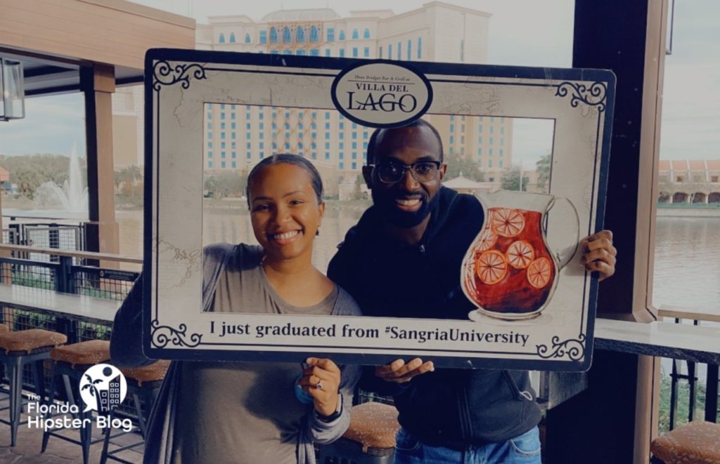 Couple poses in frame at Sangria University Graduation at Disney Coronado Springs in Orlando Florida. Keep reading for more romantic getaways in Orlando.