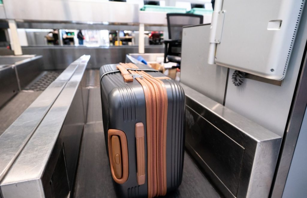 Weighing luggage at the airport. Keep reading to learn more if you can fly JetBlue with a carry-on.