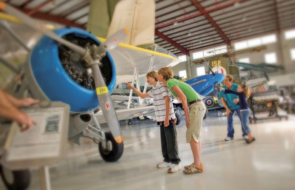 A woman and child examine a plane at the Central Florida Air Museum Fantasy of Flight in Polk City, Florida. Keep reading for more places to take a perfect day trip from Orlando, Florida. 