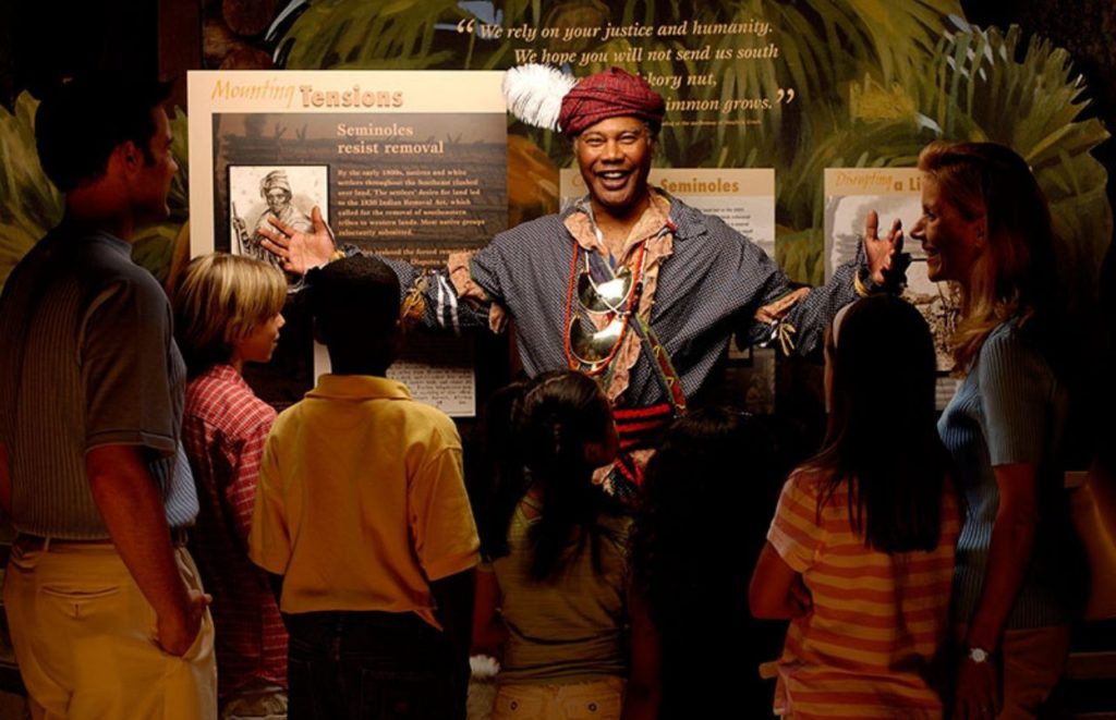 Children listen to a speaker and observe an exhibit at the Orange Country Regional History Center in Orlando, Florida. Keep reading for more places to take a perfect day trip from Orlando, Florida. 