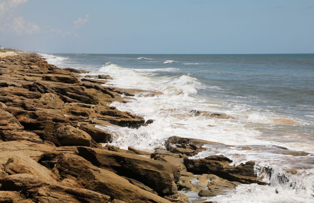 Rocky area of Flagler Beach on the Atlantic Ocean in Florida. Keep reading to discover where are the best beaches near Gainesville. 