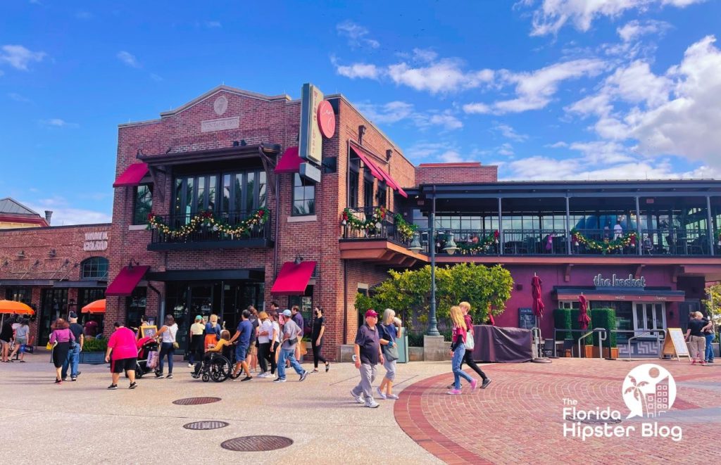 People walk in front of the brick entrance to Wine Bar George in Disney Springs in Orlando, Florida. Keep reading for more on the best restaurants in Orlando, Florida. 