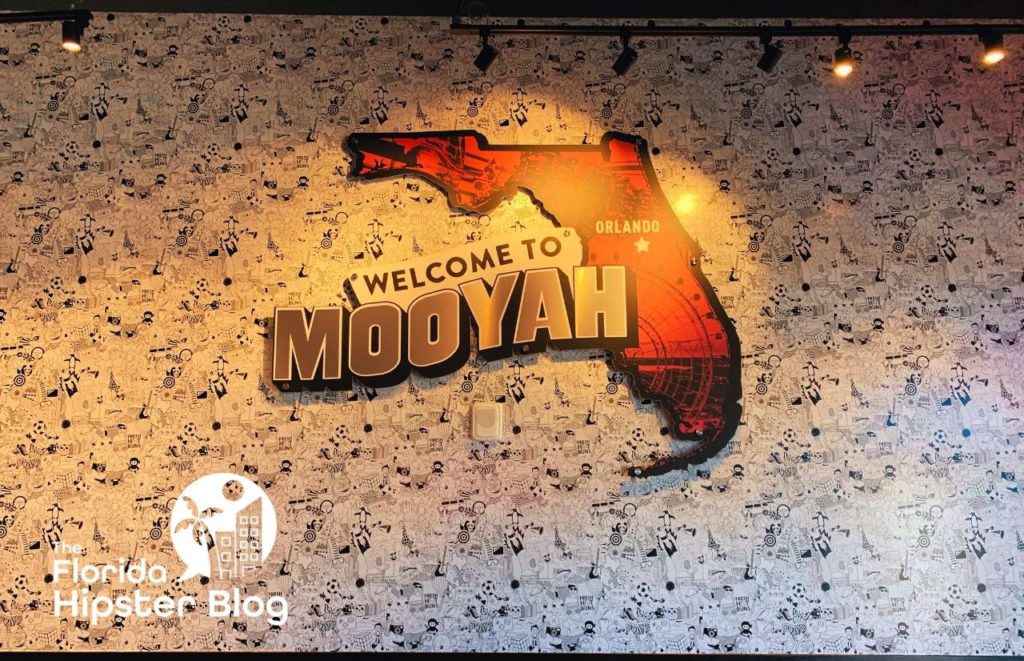 Mooyah Burgers Orlando sign on wall of map piece of Florida. Keep reading to find out where to go for the best burger in Orlando. 