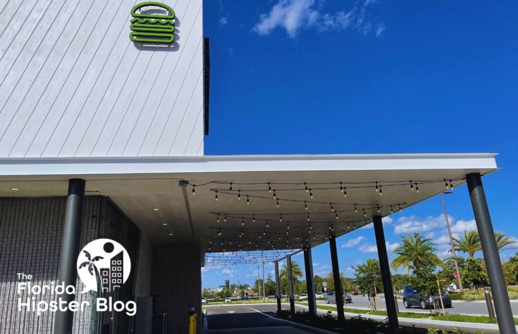 Shake Shack Burgers Orlando exterior with outdoor lighting. Keep reading to learn all you need to know about the best burger in Orlando. 