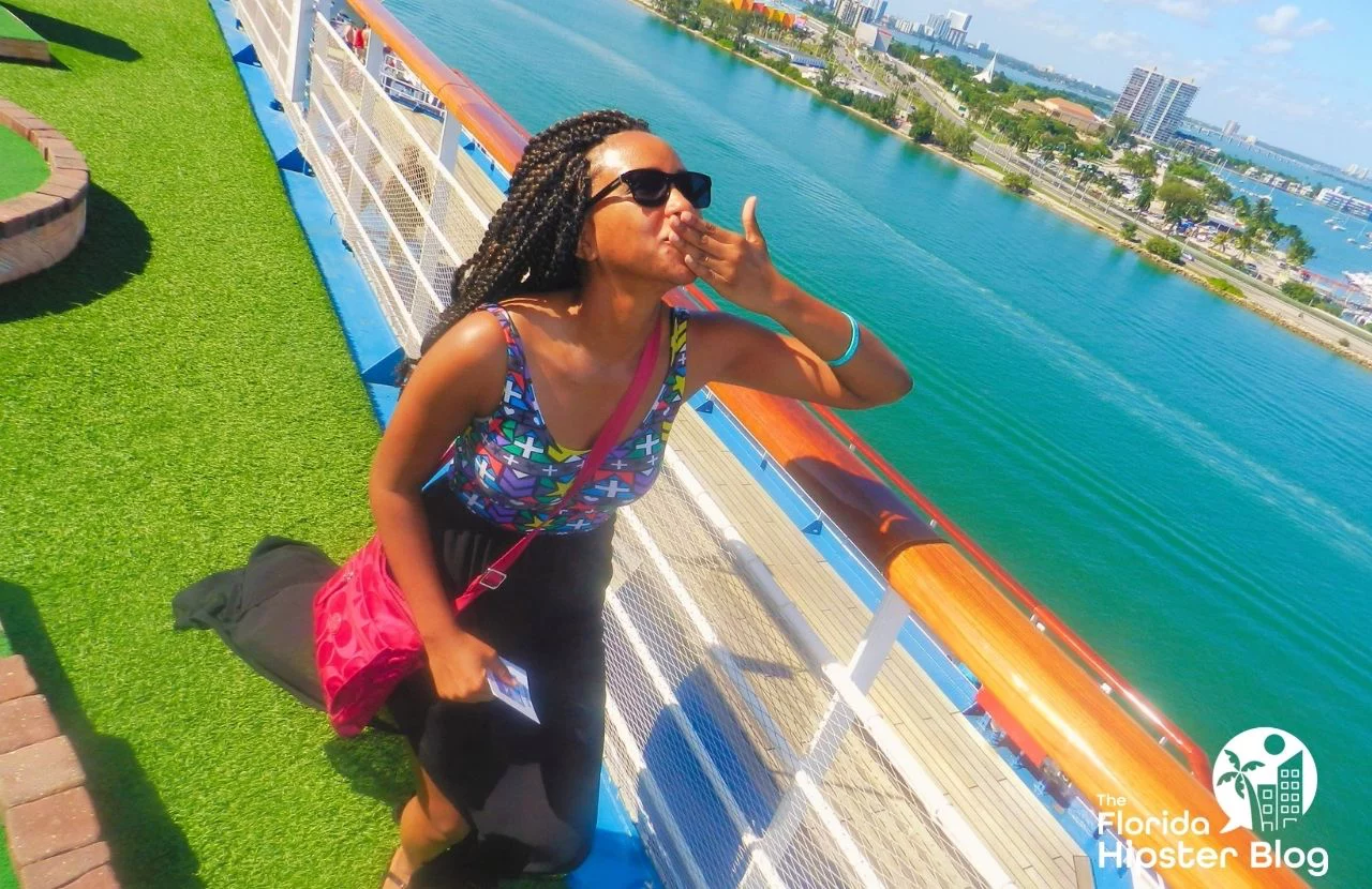 Woman poses on deck of cruise ship as it leaves port in Florida. Keep reading for more romantic getaways in Orlando.