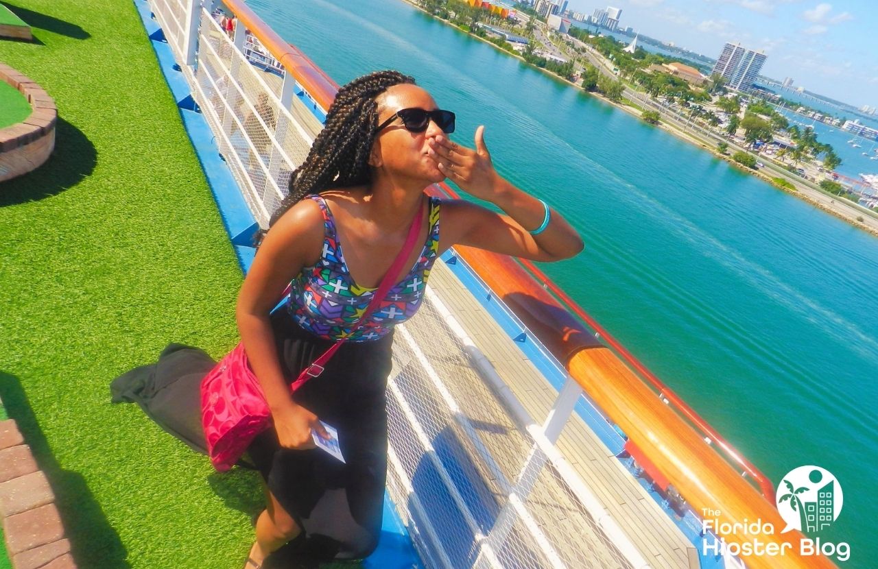 NikkyJ posing on deck of cruise ship as it leaves port in Florida. Keep reading for more romantic getaways in Orlando.