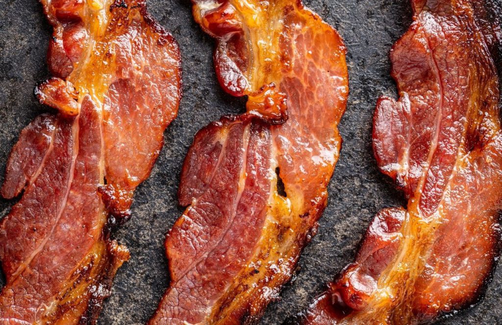 Bacon sizzles on a pan at First Watch in Tampa, Florida. Keep reading to learn about the best breakfast in Tampa.
