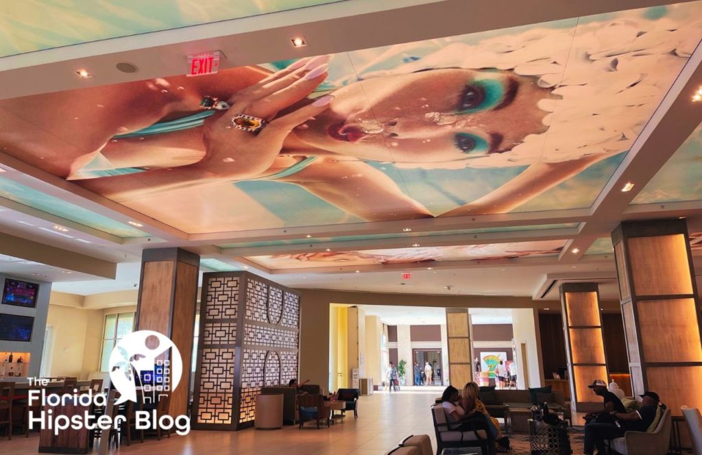 Hilton Signia Resort Orlando with a larger than life art mural on the ceiling. Keep reading to discover all there is to know about the Epicurious progressive dinner.