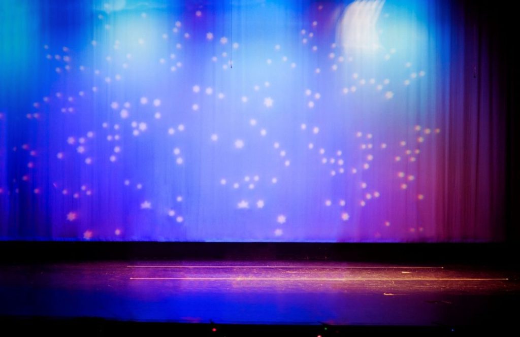 A stage with the curtain lowered with twinkling lights projected on it at Dr. Phillips Center for the Performing Arts in Orlando, Florida. Keep reading for more romantic getaways in Orlando.