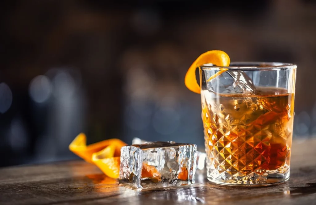 A glass of rum with ice and an orange peel sits on a table at the Strong Water Tavern at Universal's Sapphire Falls Resort in Orlando, Florida. Keep reading for more romantic getaways in Orlando.