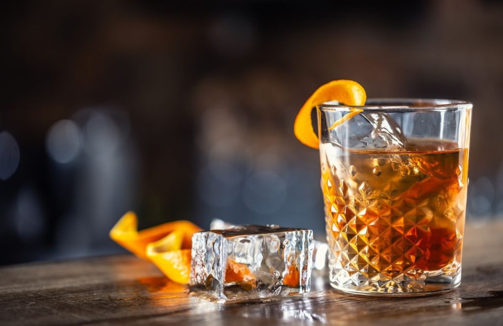 A glass of rum with ice and an orange peel sits on a table at the Strong Water Tavern at Universal's Sapphire Falls Resort in Orlando, Florida. Keep reading for more romantic getaways in Orlando.