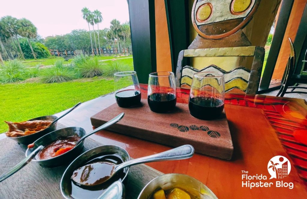 Sanaa Restaurant in Disney's Animal Kingdom Lodge Resort with a table full of dips and wine with a view of the African Kingdom. Keep reading to learn more about Orlando nightlife.