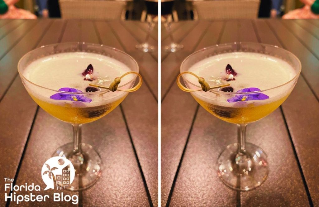 Waldorf Astoria Orlando colorful Martini with flowers. Keep reading to find out more about the best restaurants in Orlando at Hilton Signia Hotel and Waldorf Astoria. 