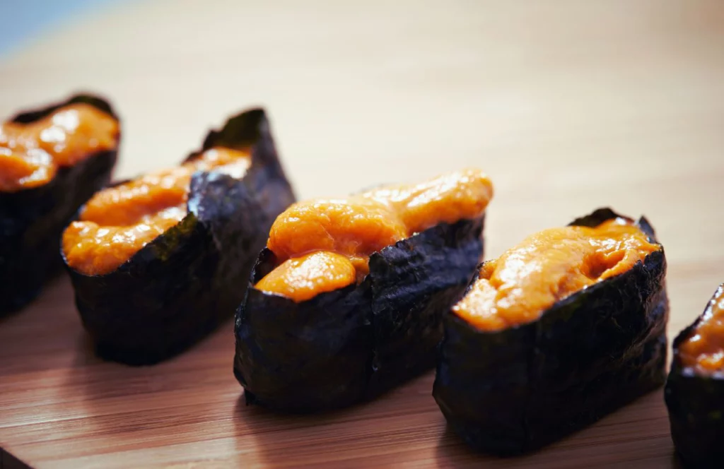 A sushi role sits on a wood board at BluWave Sushi in Tampa, Florida. Keep reading for more places to get the best sushi in Tampa, Florida.
