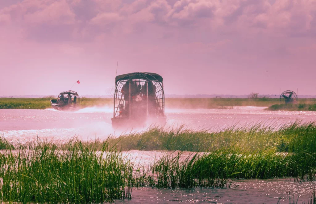 An airboat speeds through the water at Boggy Creek Airboat Adventures in Kissimmee, Florida. Keep reading for more places to take a perfect day trip from Orlando, Florida.