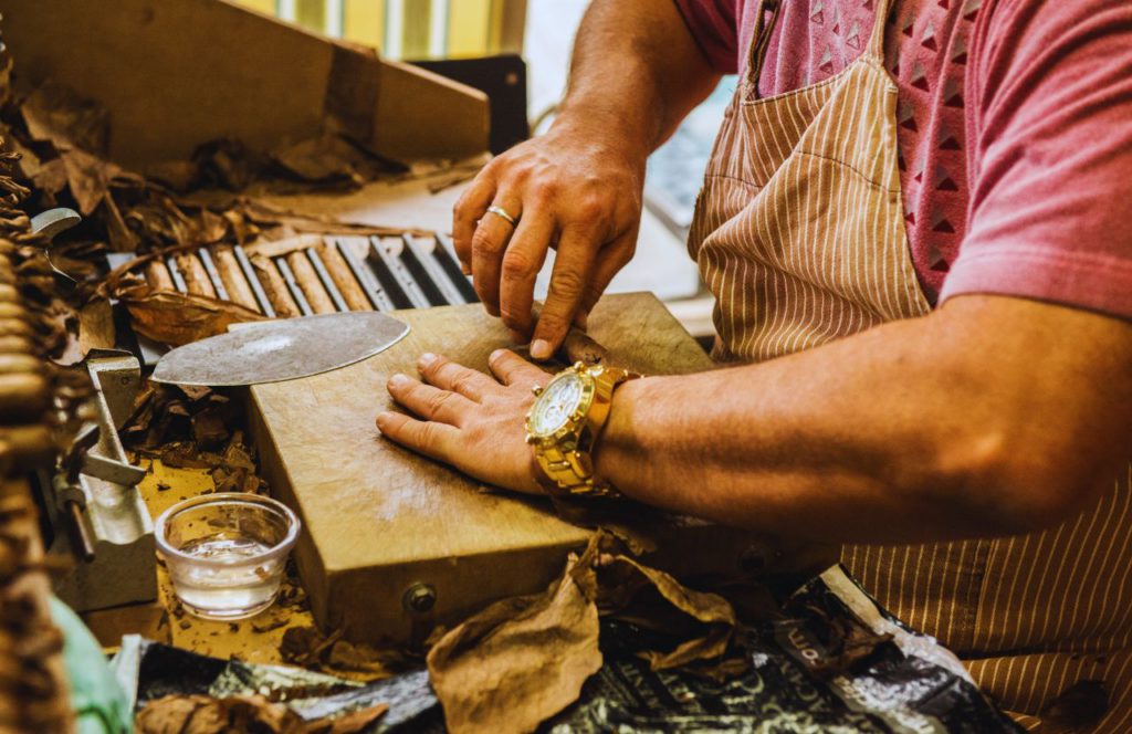 A man rolls a cigar in Ybor City in Tampa, Florida. Keep reading for more places to take a perfect day trip from Orlando, Florida. 