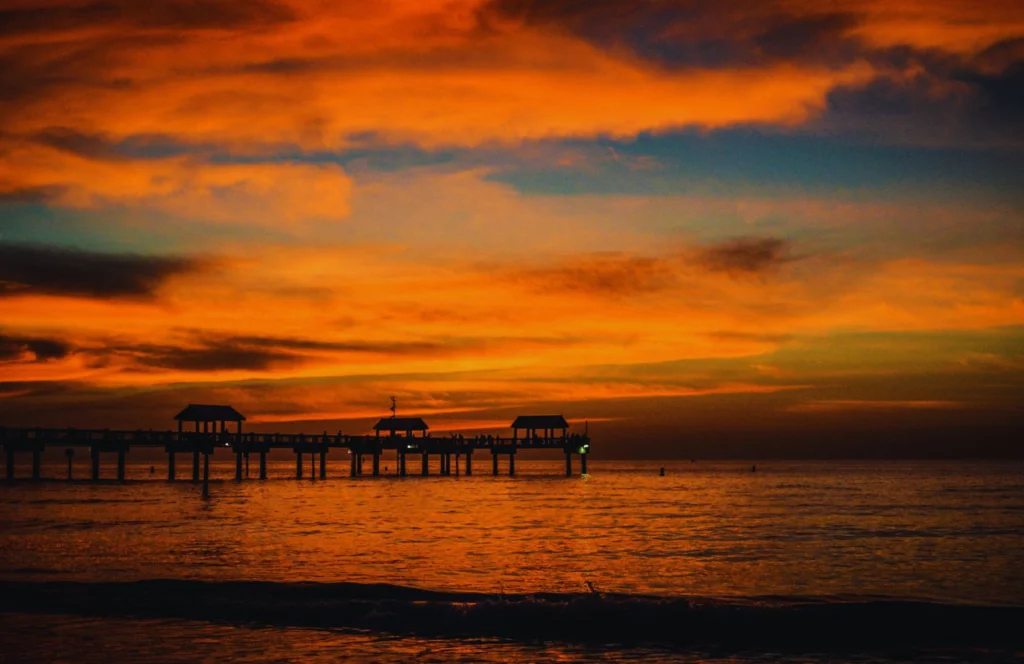A sunset view of a dock at Clearwater Beach in Florida. Keep reading for more places to take a perfect day trip from Orlando, Florida.