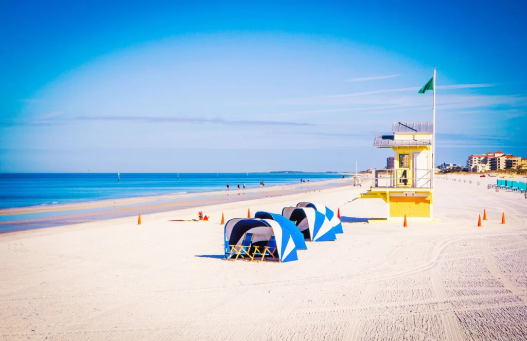 Several chairs and sun tents sit on the beach at Clearwater Beach in Florida. Keep reading for more places to take a perfect day trip from Orlando, Florida.
