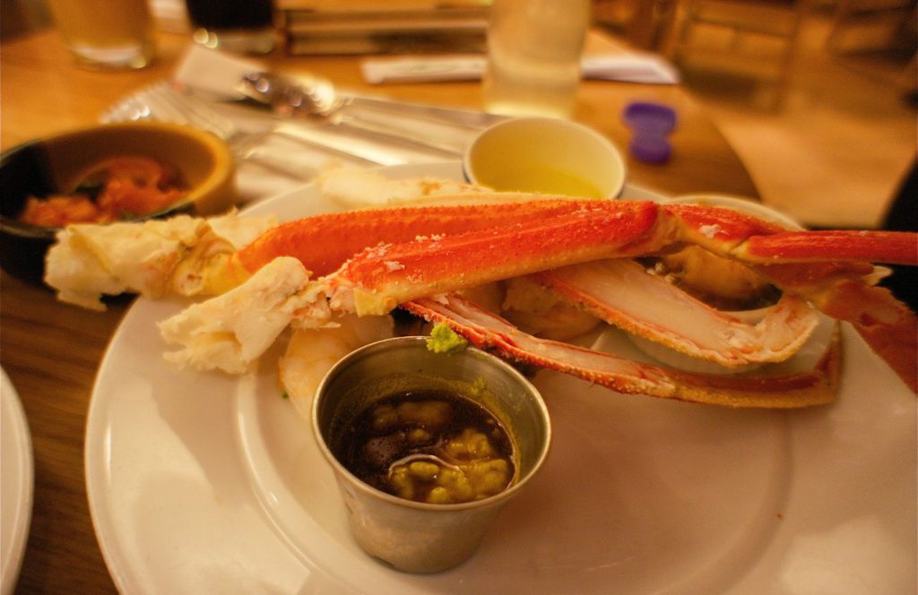 Crab served with melted butter and other dipping sauce at Hungry Crab in Orlando, Florida. Keep reading to discover where to go for the best crab legs in Orlando. 