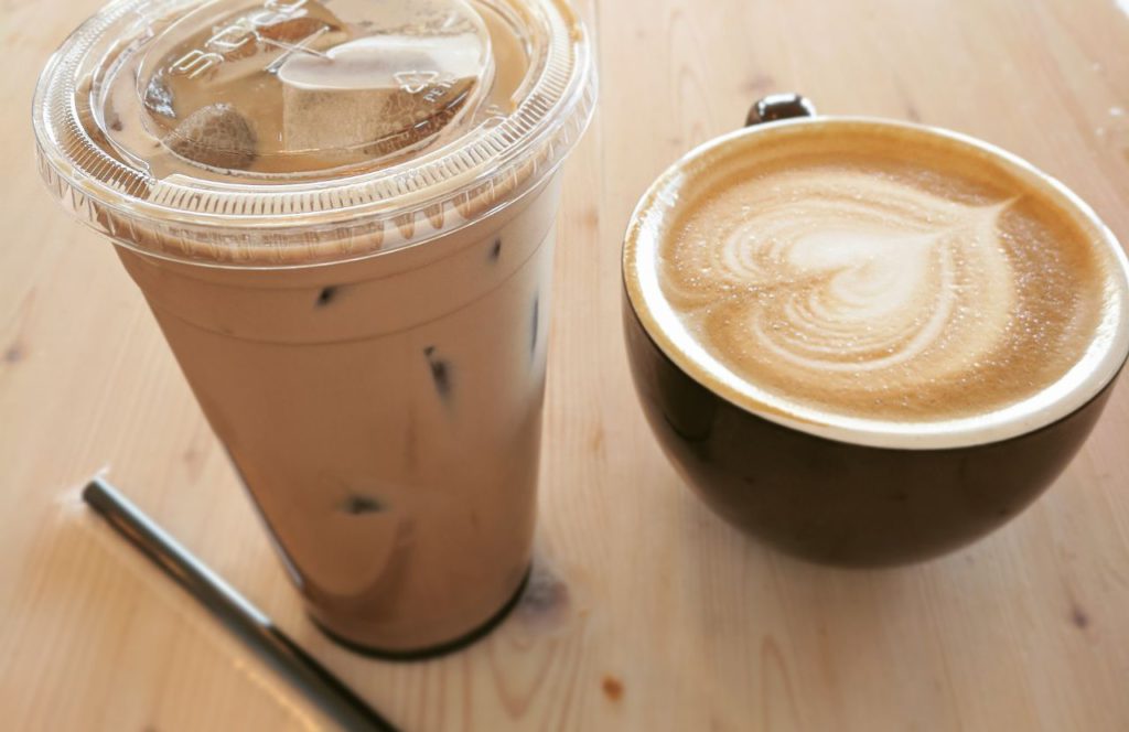 Iced coffee and a cup of coffee with milk art on top. Keep reading to learn more about the best places to go for dessert in Orlando. 
