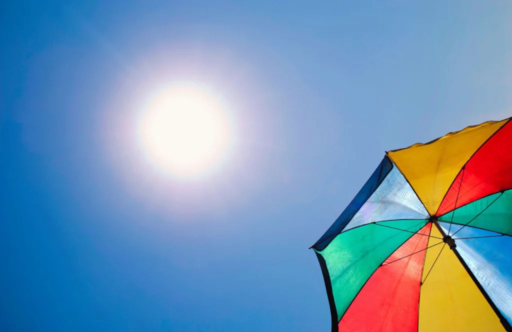 Rainbow umbrella in the Florida sun. Keep reading to find out more about snorkeling in Panama City Beach.