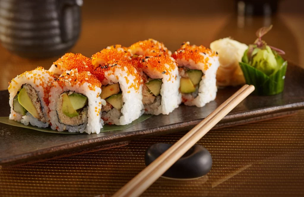 A sushi roll and chopsticks sit on a plate at Yoko's in Tampa, Florida. Keep reading for more places to get the best sushi in Tampa, Florida.