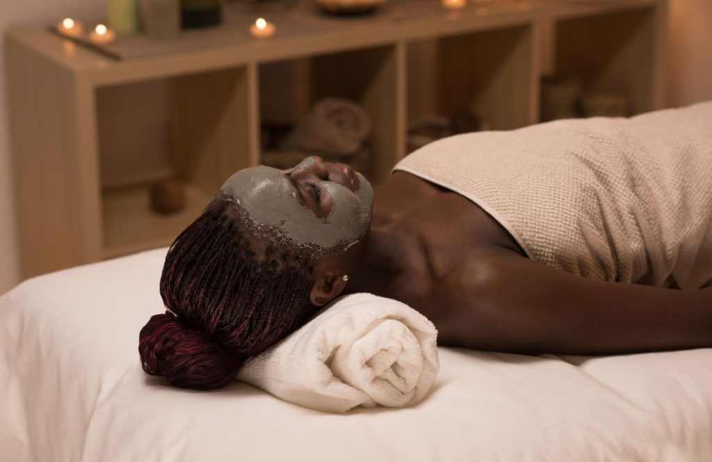 Black Woman on Table with Facial Mask at Spa Jardin. Keep reading to discover the best day spas in Tampa.  