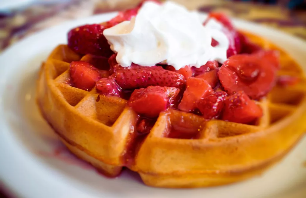 Strawberries and Whipped Cream on top of waffle The Brunchery. Keep reading to learn about the best breakfast in Tampa.
