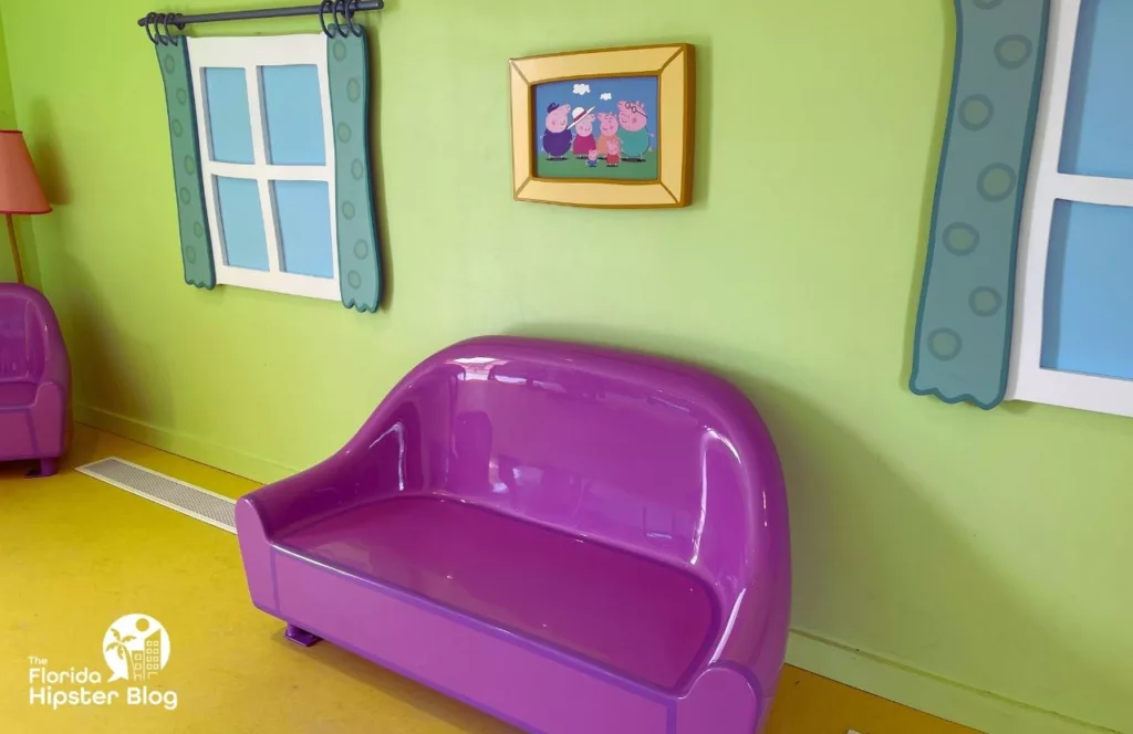 Peppa Pig Theme Park Florida Daddy Pig Roller Coaster with purple couch in Peppa Pig's House. Keep reading to learn how to plan a day at Peppa Pig Theme Park.  